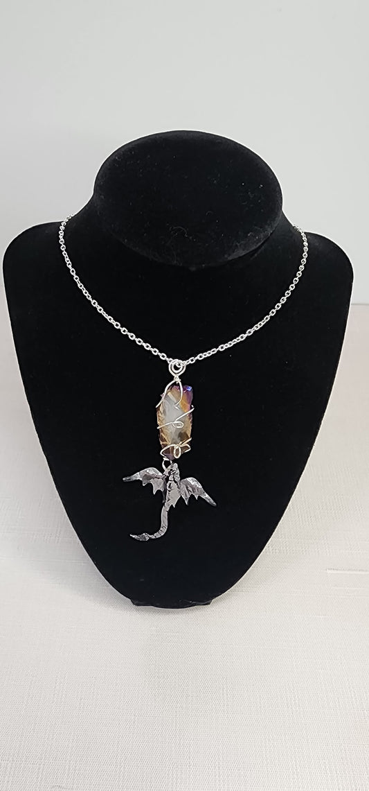 Necklace with a dragon pendant on a black velvet stand against a white background