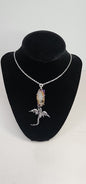 Necklace with a dragon pendant on a black velvet stand against a white background